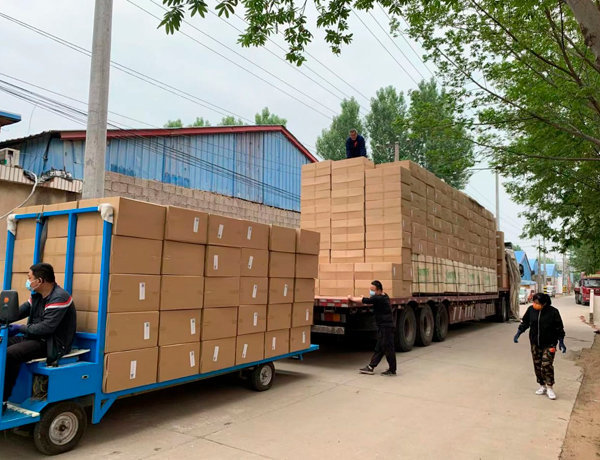 Детские коврики в картонных коробках погружены в открытый прицеп перед отправкой на склад перегруза в Хуньчунь (импорт из Китая в Москву).